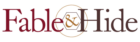 Fable&Hide logo. Fable is in maroon, & is in gold and surrounded by a hexagon and a circle, hide is in brown